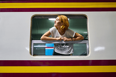 Eine Person steht im Zug und schaut aus dem offenen Fenster